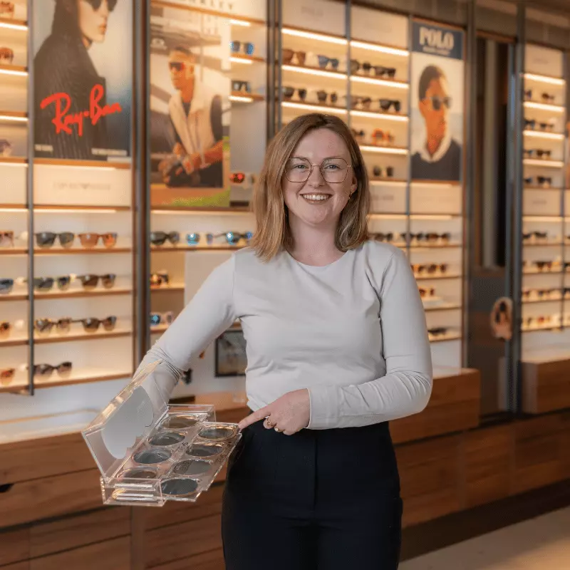 Pearle medewerker met transitions glazen voor een brillenwand